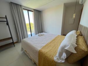 a bedroom with a bed and a large window at Casa da Laguna - Costa do Sauipe in Costa do Sauipe