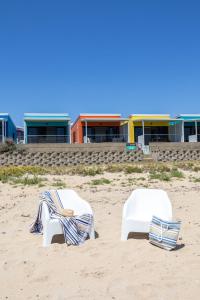 two chairs sitting on the sand on the beach at Port Lincoln Beachfront Apartments in Port Lincoln