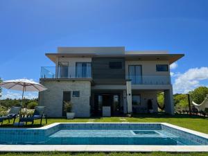 a house with a swimming pool in front of a house at Casa da Laguna - Costa do Sauipe in Costa do Sauipe