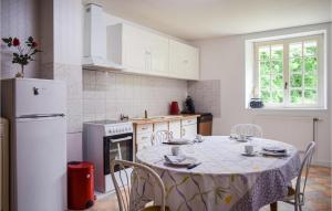 una cucina con tavolo e frigorifero bianco di 3 Bedroom Gorgeous Home In Langoat a Langoat