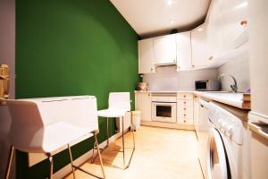 マドリードにあるMyHouseSpain - Bright apartment in Historical City Centerの緑の壁と白いキャビネット付きのキッチン