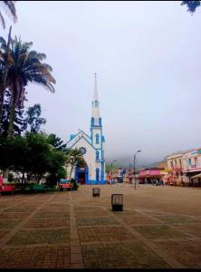 a church with a clock tower in a town at JARDIN CAFETERO in Trujillo