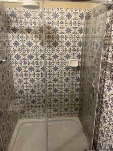 La salle de bains est pourvue d'une douche avec du carrelage bleu et blanc. dans l'établissement LACASADELCORONEL, à Quito