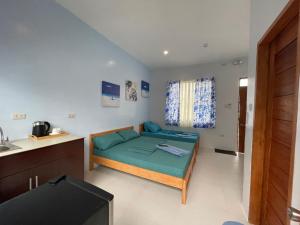 a small room with a bed and a kitchen at Blue Summer Suites in Bingag