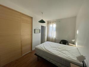 a bedroom with a bed and a wooden closet at Maison Capbreton, 3 pièces, 4 personnes - FR-1-413-116 in Capbreton