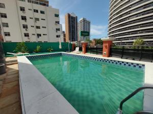 une piscine sur le toit d'un immeuble avec des bâtiments dans l'établissement Meireles 5 pessoas LC FLATS 1307, à Fortaleza
