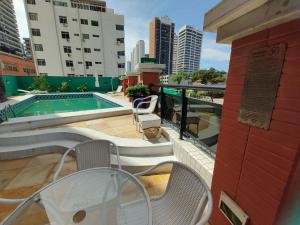 d'un balcon avec une table et des chaises, ainsi que d'une piscine. dans l'établissement Meireles 5 pessoas LC FLATS 1307, à Fortaleza