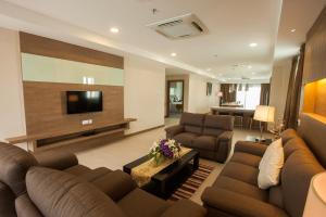 a living room with two couches and a television at Garden Sentral Hotel in Kuala Belait