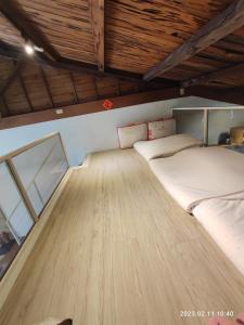 a bed in a room with a wooden floor at Humble Room in Hualien City