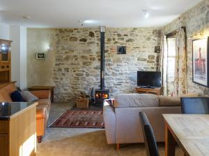 a living room with a couch and a fireplace at Turneys Cottage - Uk42115 in Bodmin