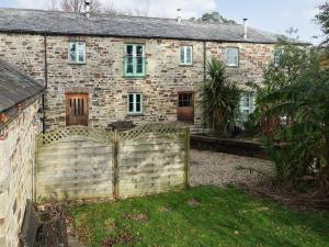 an old brick house with a fence in front of it at Turneys Cottage - Uk42115 in Bodmin