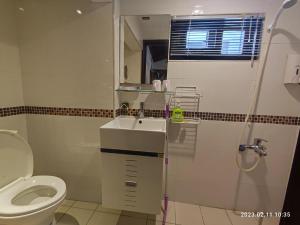 a bathroom with a sink and a toilet at Humble Room in Hualien City