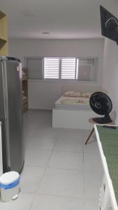 eine Küche mit einem Kühlschrank und einem Bett darin in der Unterkunft Studio em Cachoeira Paulista in Cachoeira Paulista