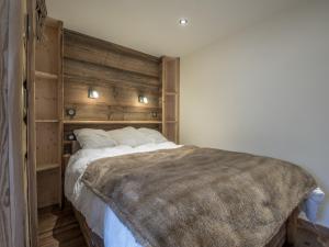 a bedroom with a large bed with a wooden headboard at Appartement Méribel, 3 pièces, 4 personnes - FR-1-613-1 in Méribel