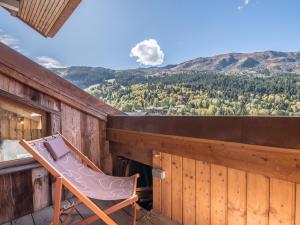 a chair on the balcony of a cabin with a view at Appartement Méribel, 3 pièces, 4 personnes - FR-1-613-1 in Méribel
