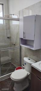 uma casa de banho com um WC branco e um chuveiro em Casa Quinta Flower em Melgar