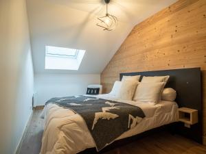 een slaapkamer met een bed met een houten muur bij Appartement Valmorel, 5 pièces, 8 personnes - FR-1-356-417 in Valmorel