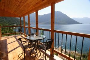 a table and chairs on a balcony with a view of the water at Villa Strp in Risan