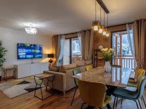 salon ze stołem i kanapą w obiekcie Les Gets - Moderne appartement, 1.5km du centre, 400m des pistes, terrasse, 2 chambres, WiFi, parking - FR-1-623-339 w mieście Les Gets