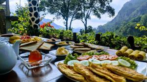 a table topped with plates of food on a table at Lavendra Paradise in Ella