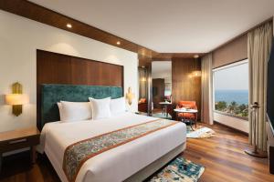 a hotel room with a large bed and a large window at Welcomhotel by ITC Hotels, Devee Grand Bay, Visakhapatnam in Visakhapatnam