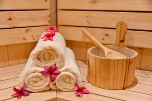 a towel with flowers on it next to a wooden bowl at Welcomhotel by ITC Hotels, Devee Grand Bay, Visakhapatnam in Visakhapatnam