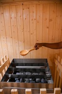a person holding a wooden spoon over a stove at Welcomhotel by ITC Hotels, Devee Grand Bay, Visakhapatnam in Visakhapatnam