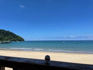 a hat sitting on a fence on a beach at Tiongman Scubadive & Lodge in Tioman Island