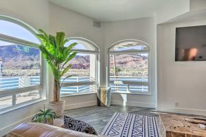 a living room with two windows and a plant at Spacious Parker House on the Colorado River! in Parker