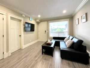 a living room with a black couch and a table at New two-bedroom legal suite with parking in White Rock