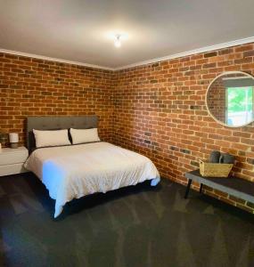 a bedroom with a bed in a brick wall at Jeryn On Jephcott in Corryong