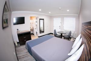 a bedroom with a bed and a desk and a table at Diamond Bell Inn & Suites in Bell