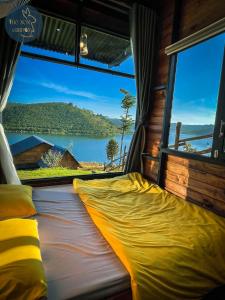 a bed in a room with a large window at Thỏ Non Garden Villa Bảo Lộc in Bao Loc