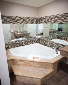 een groot bad in een badkamer met 2 wastafels bij Diamond Bell Inn & Suites in Bell