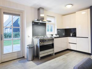 a kitchen with a stove top oven next to a window at Rustic Holiday Home In Wissenkerke With Garden in Wissenkerke