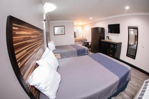 a bedroom with a large bed with a wooden headboard at Diamond Bell Inn & Suites in Bell
