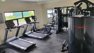a gym with several tread machines in a room at Summer Breeze Villa in Lucea