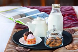 a plate with a cupcake and a bottle of milk at Resort Amanzi in Lonavala