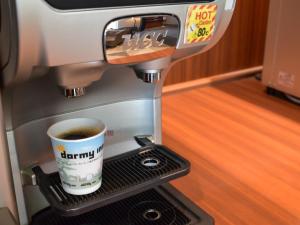 a coffee machine with a cup of coffee at Dormy Inn Premium Kyoto Ekimae Natural Hot Spring in Kyoto