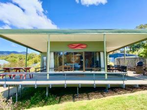 a house with a large roof with a patio at Spring Beach Retreat in Spring Beach +19 photos