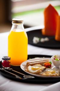 a plate of food and a bottle of orange juice at Resort Amanzi in Lonavala