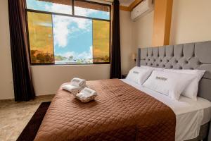1 dormitorio con 1 cama y ventana grande en Sonqu Tarapoto, en Tarapoto