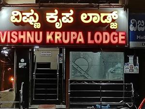 um sinal para um alojamento de turismo selvagem Kiryu Kruppha num edifício em Sri vishnu krupa lodging em Belūr