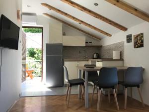 a kitchen with a table and chairs in a room at Apartments Luki - great view in Smergo