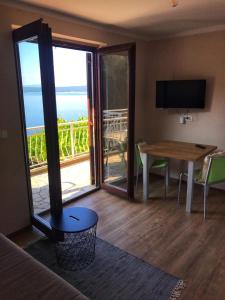 ein Wohnzimmer mit einem Tisch und Meerblick in der Unterkunft Apartments Luki - great view in Smergo