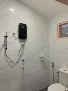 瓜埠的住宿－VILLA TASIK TONGKANG KELI LANGKAWI，一间带卫生间的浴室和墙上的一部电话