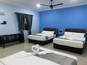 瓜埠的住宿－VILLA TASIK TONGKANG KELI LANGKAWI，一间卧室设有两张床和蓝色的墙壁