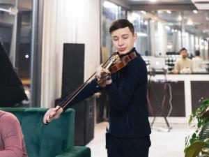 a man playing a trombone in a room at Deluxe Ferghana Hotel in Fergana