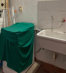un baño con una lona verde sobre un lavabo en Like home en Salta