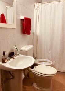 Baño blanco con aseo y lavamanos en Like home en Salta
